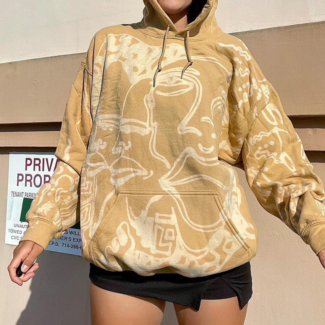 Abstract faces, spiral geometric pattern, and celestial sun print style hoodie in golden tan/yellow and white/ cream