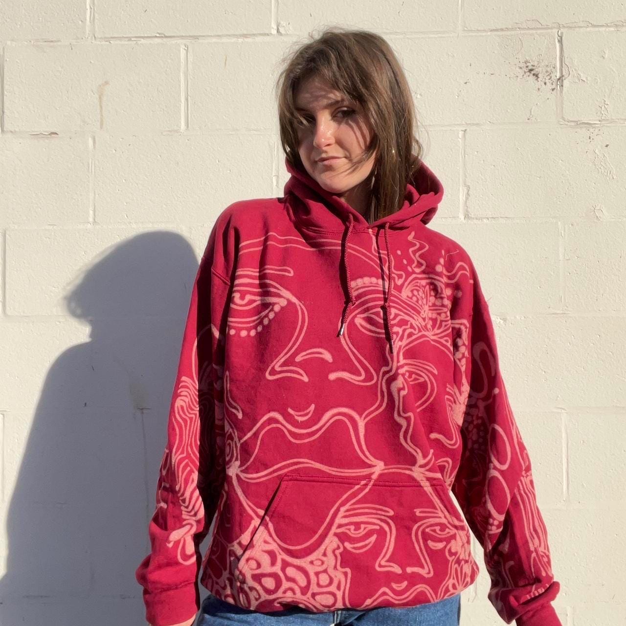 .Abstract faces, floral pattern, and geometric style hoodie in burgandy and cream